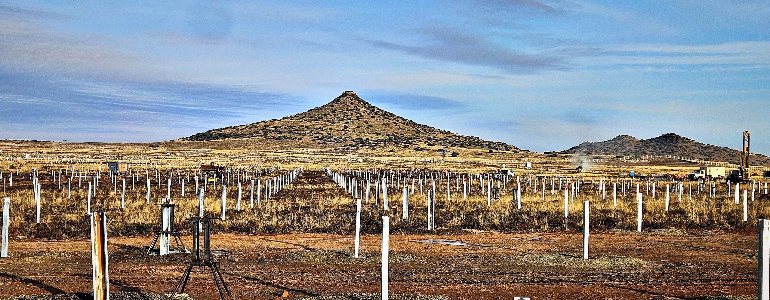 Panoramic view of installed steel piles stretching toward the hills at the Mooiplaats solar PV site